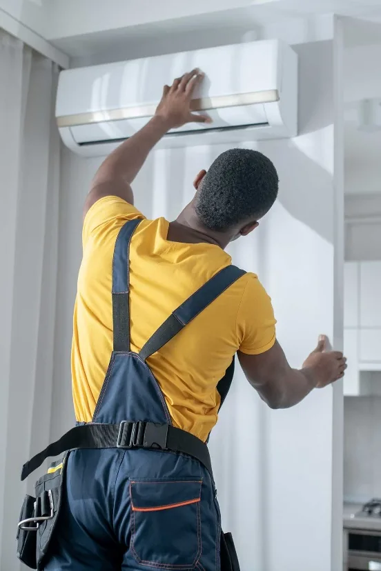 Technicien d’Arkyda posant un climatiseur mural dans un logement