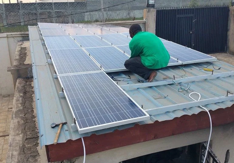 Technicien posant des panneaux solaires sur la toiture d’un bâtiment